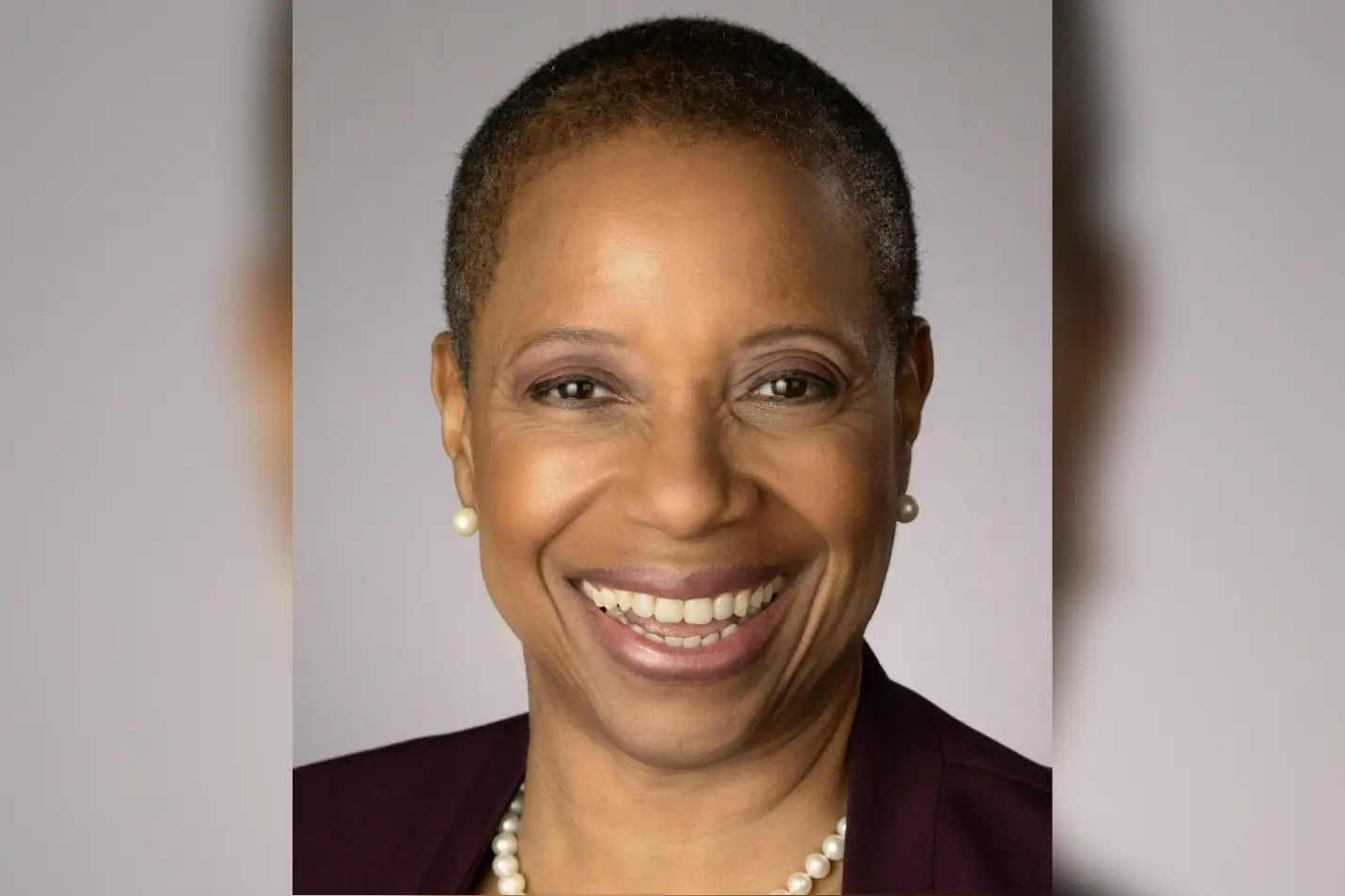 A woman with short hair smiles for the camera.