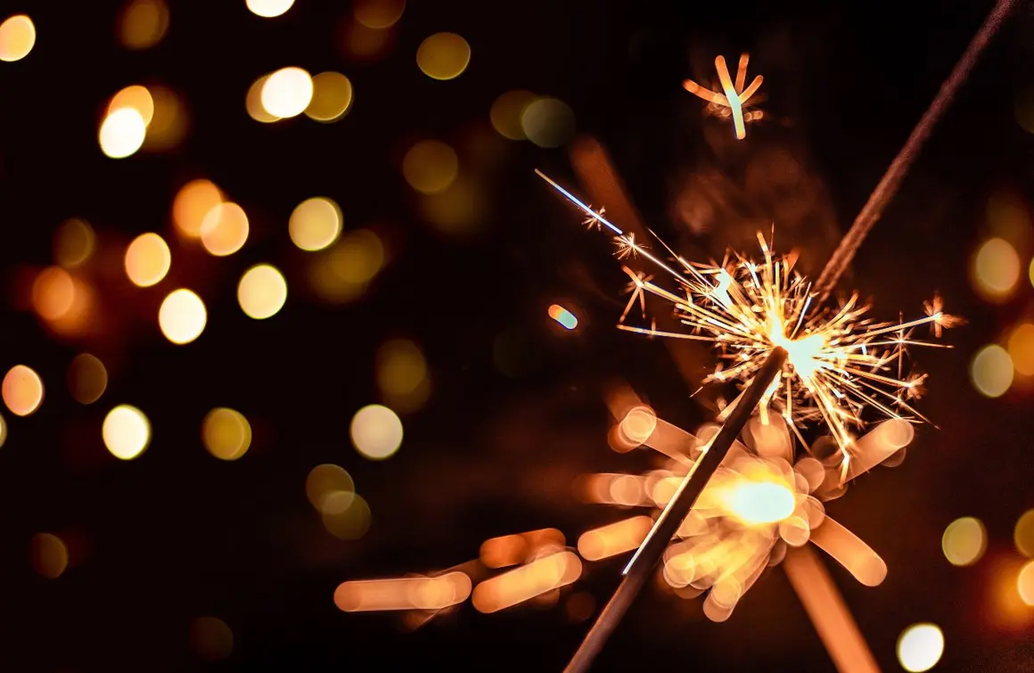 A sparkler with lights in the background